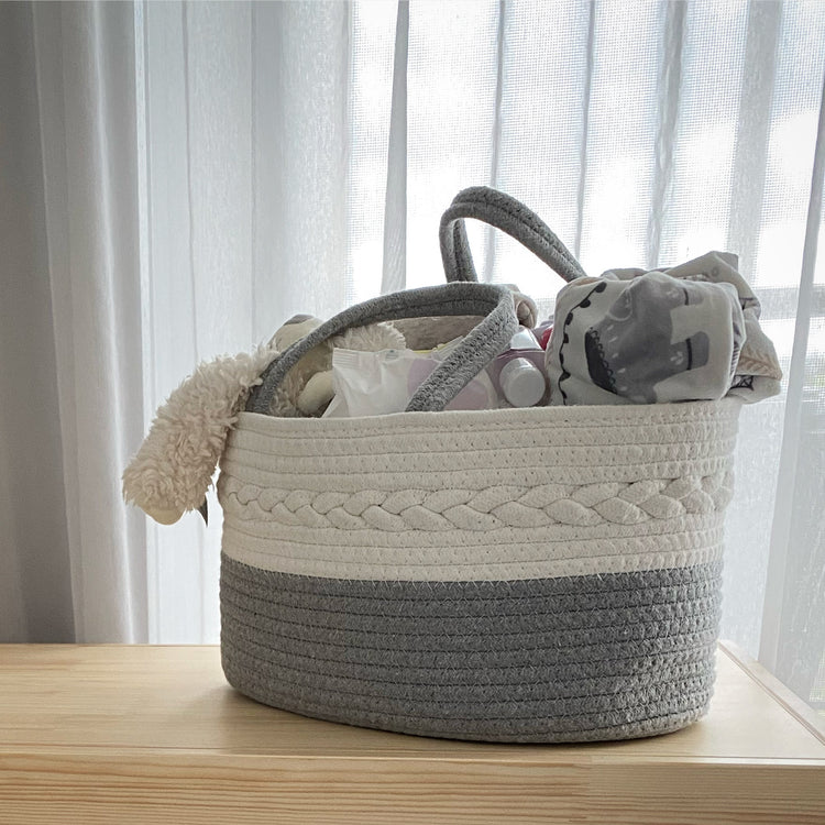 Luxury grey and white rope caddy with braided detailing. Stores toys, nappies and general baby organisation needs. Pictured on a wooden toy chest in a blonde timber, full of toys, baby whites and more.
